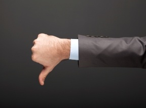 Investor in a business suit giving a thumbs down to horrible self-directed IRA custodians